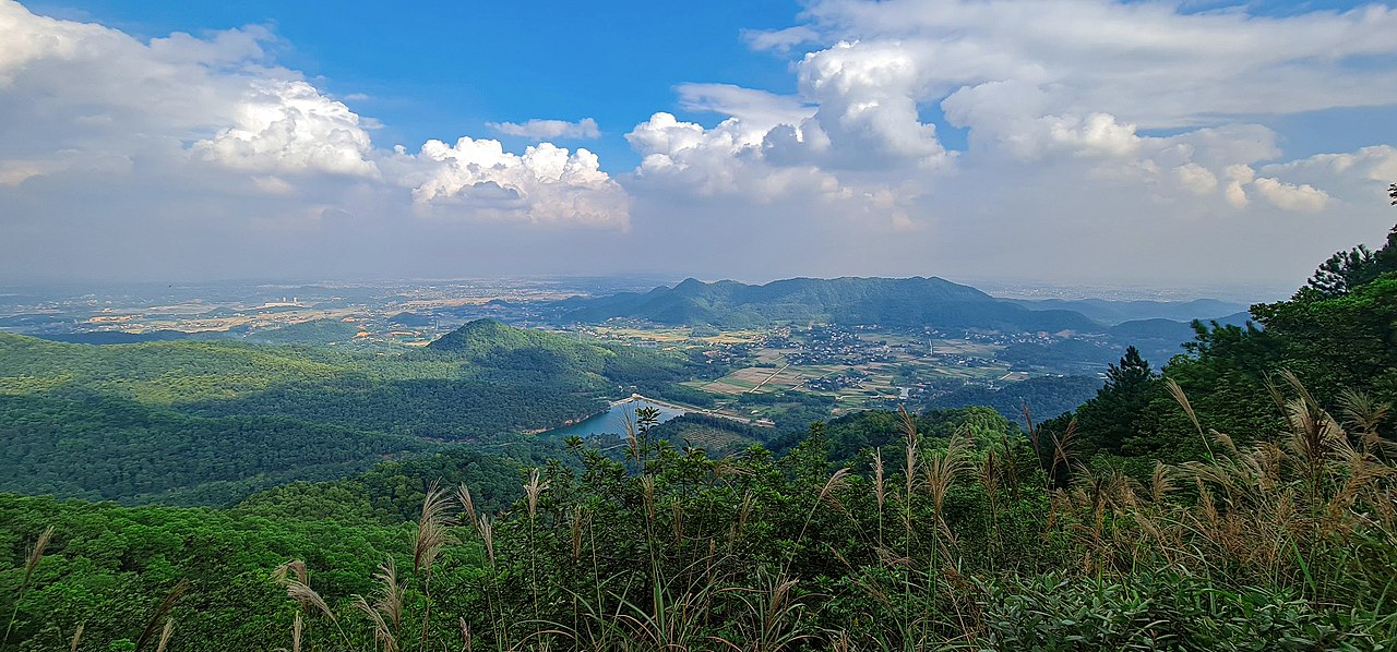 Quang cảnh trên đỉnh Hàm Lợn, phía xa là núi Sóc. Ảnh: NKSTTSSHNVN/Wikimedia Commons