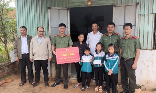 Công an tỉnh Đắk Nông trao tặng thẻ bảo hiểm y tế cho các em học sinh có hoàn cảnh khó khăn. Ảnh: Phan Tuấn 