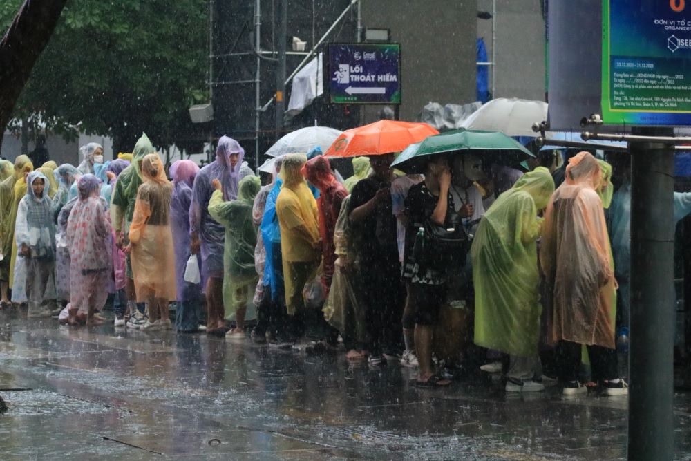   Ghi nhận khu vực phố đi bộ Nguyễn Huệ nhiều người vẫn đội mưa chờ được vào khu vực check-in countdown đón năm mới.