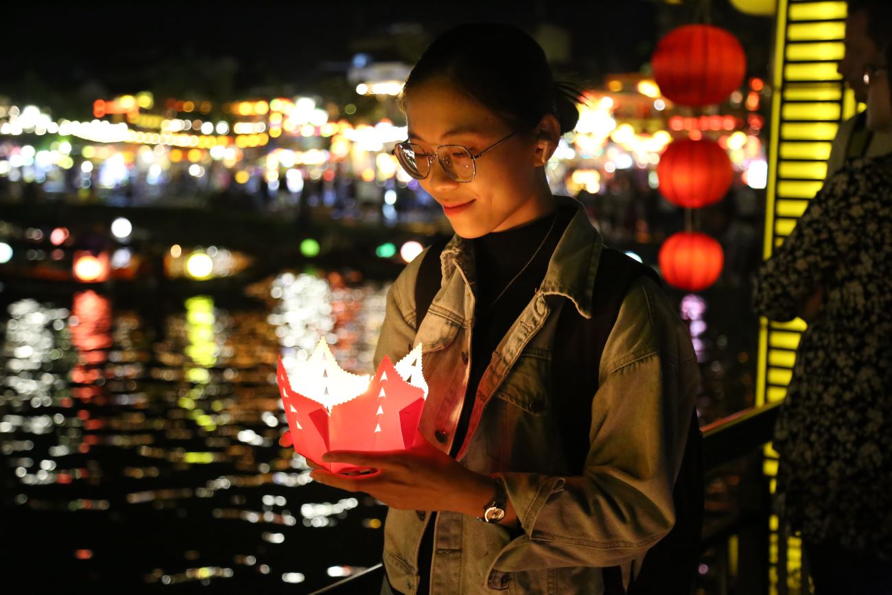 Du khách mua đèn hoa đăng để thả trôi trên sông Hoài.