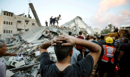 Lực lượng cứu hộ và dân thường dọn đống đổ nát sau cuộc tấn công của Israel vào thị trấn Deir Al-Balah, ở trung tâm Dải Gaza ngày 15.10.2023. Ảnh: AFP