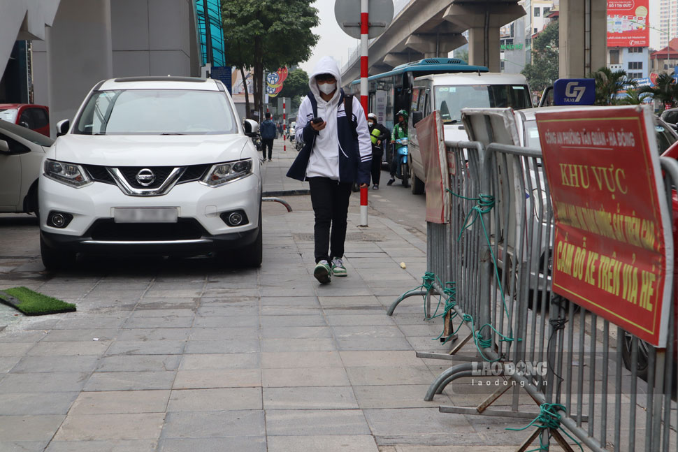 Dù đã có biển báo cấm đỗ xe ô tô trên vỉa hè tại ga Văn Quán, nhưng nhiều chủ phương tiện vẫn phớt lờ biển báo. Ảnh: Thảo Trang