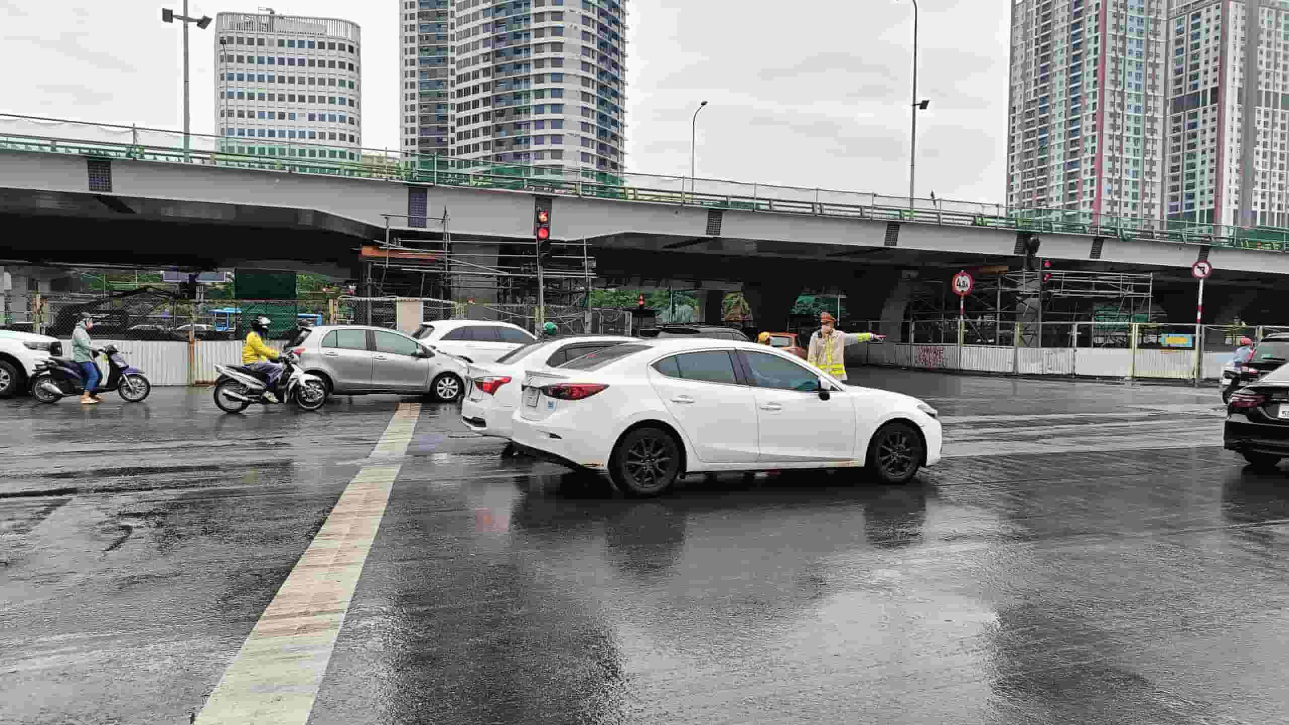 Khu vực nút giao đường Phạm Văn Đồng - Xuân Thủy cũng trong tình trạng ùn tắc kéo dài. Lực lượng cảnh sát giao thông phối hợp cùng công nhân công trường điều tiết giao thông, giảm tải ùn tắc.