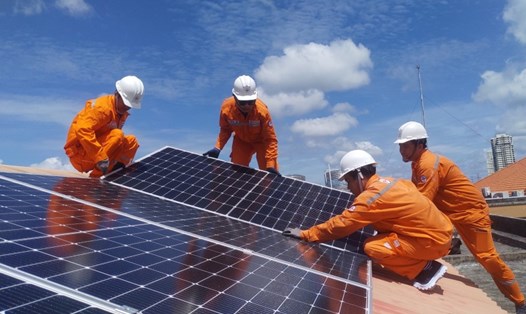 Công nhân EVNHCMC lắp đặt điện mặt trời mái nhà tặng một trường học trên địa bàn TPHCM. Ảnh: Đức Long