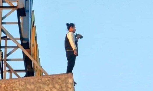 Cô gái đứng trên nóc tòa nhà cao 25 tầng định tự tử.   Ảnh: Hải Đăng 