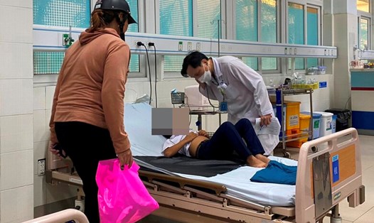 Các y bác sĩ của Bệnh viện Sản - Nhi tỉnh Quảng Ngãi đang thăm khám, theo dõi tình hình sức khoẻ của các em học sinh nghi ngờ ngộ độc thực phẩm. Ảnh: Ngọc Viên