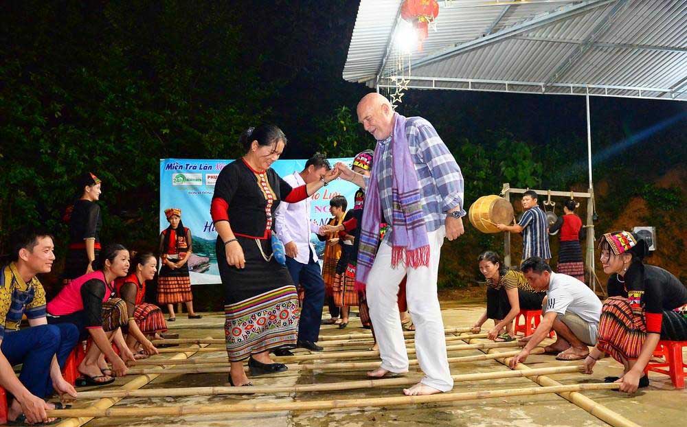 Du khách nước ngoài say sưa với điệu nhảy sạp tại điểm du lịch cộng đồng bản Khe Rạn, xã Bồng Khê, huyện Con Cuông. Ảnh: Hải Đăng