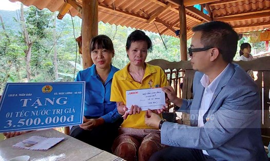 Phóng viên Báo Lao Động và đại diện Liên đoàn Lao động huyện Tuần Giáo, tỉnh Điện Biên trao 20 triệu đồng từ Quỹ Tấm lòng Vàng cùng các phần quà. Ảnh: Diệu Thúy