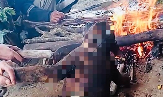 Hình ảnh đăng trên TikTok cho thấy nam thanh niên cùng 1 người khác đang nướng cháy 1 cá thể khỉ. Ảnh chụp màn hình: Hương Giang