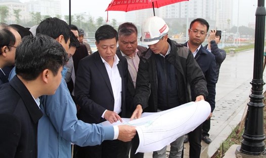 Phó Chủ tịch UBND TP Hà Nội Dương Đức Tuấn kiểm tra bản vẽ và hiện trạng thực tế của dự án đầu tư Công viên hồ điều hòa CV1. Ảnh: Công Trình