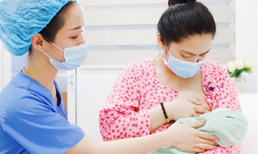 Nhân viên y tế hỗ trợ mẹ cho bé bú ngay sau sinh. Nguồn ảnh: Bệnh viện Phụ sản Hà Nội