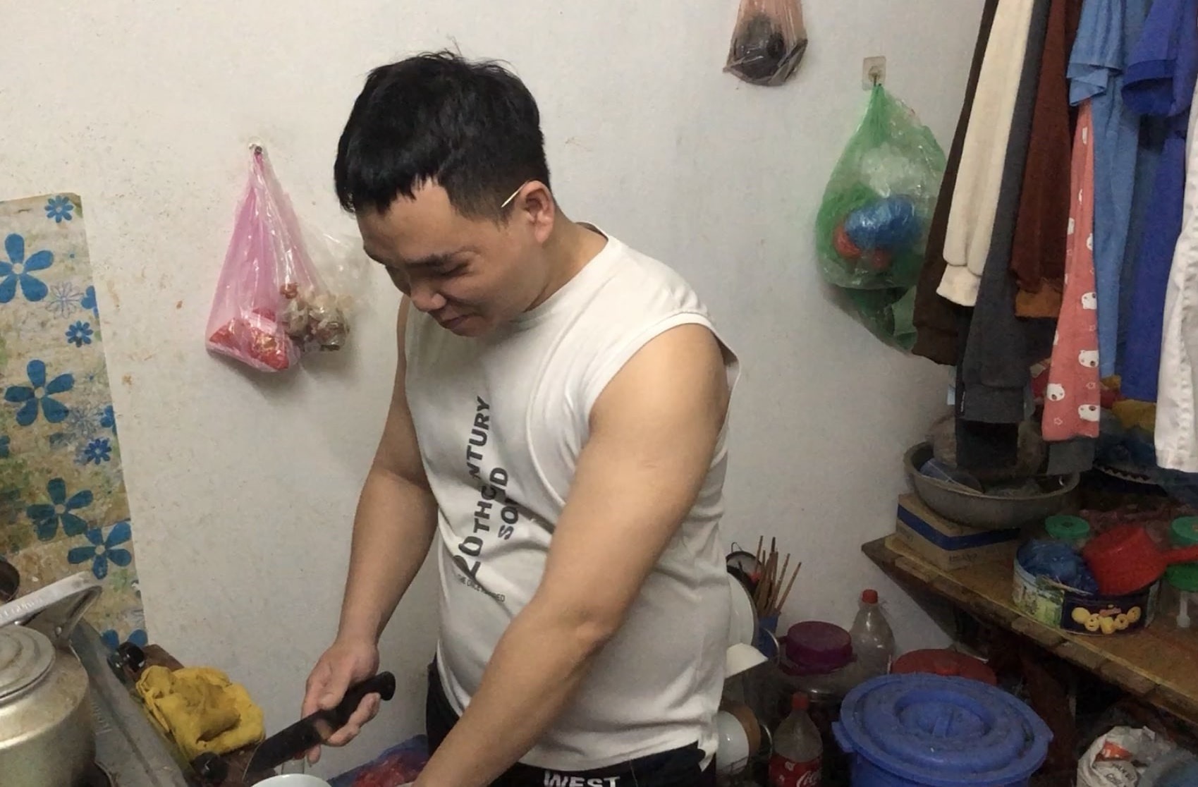 Anh Nguyễn Văn Tâm nấu ăn trong căn phòng trọ chật chội tại thôn Hậu Dưỡng, xã Kim Chung, huyện Đông Anh, Hà Nội. Ảnh: Phương - Hân