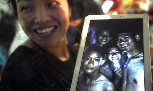 Bà Thanaporn Promthep, mẹ của Duangpetch Promthep, chia sẻ ảnh của con trai bà (ở giữa, cầm nguồn sáng) cùng huấn luyện viên và đồng đội sau khi mắc kẹt trong hang. Ảnh: AFP