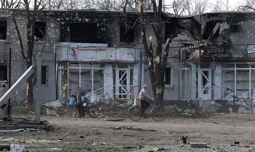Cư dân bên ngoài một tòa nhà bị hư hại ở Volnovakha của Donetsk, Ukraina ngày 15.3.2022. Ảnh: Xinhua