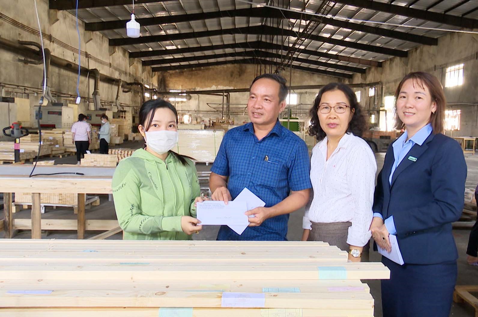 LĐLĐ tỉnh Bình Dương, LĐLĐ thị xã Tân Uyên cùng đại diện ngân hàng trao hỗ trợ cho công nhân gặp khó khăn do công ty bị hỏa hoạn. Ảnh: Hoàng Trung