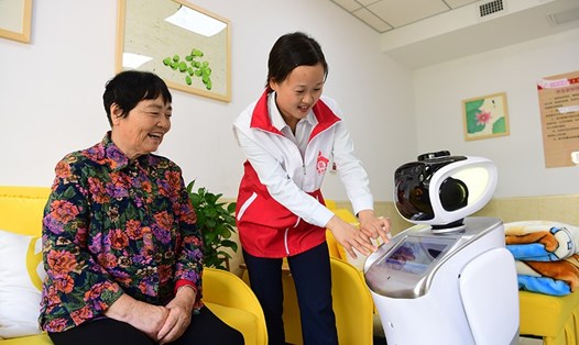 Một nhân viên điều dưỡng hướng dẫn cách dùng robot tích hợp AI tại một viện dưỡng lão ở thành phố Hợp Phì, tỉnh An Huy, Trung Quốc. Ảnh: Xinhua