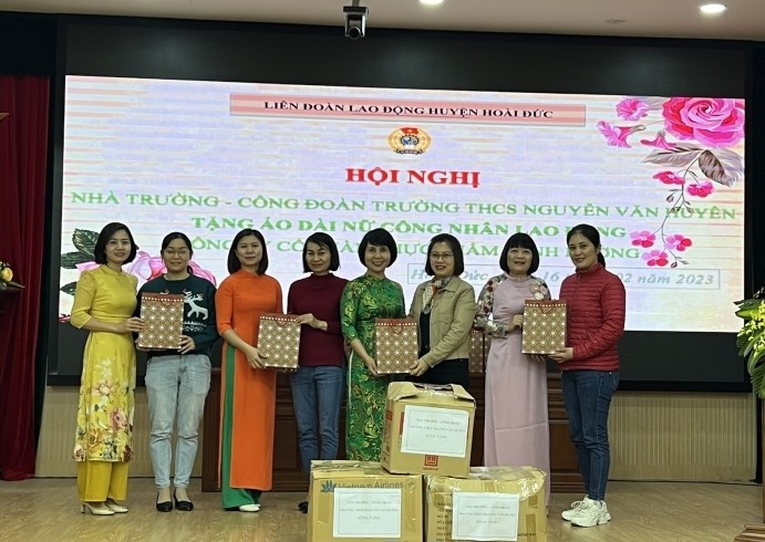 Ban chấp hành Công đoàn trường THCS Nguyễn Văn Huyên trao tặng áo dài cho Công ty Cổ phần thực phẩm Minh Dương. Ảnh: Anh Tuấn