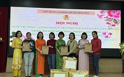 Ban chấp hành Công đoàn trường THCS Nguyễn Văn Huyên trao tặng áo dài cho Công ty Cổ phần thực phẩm Minh Dương. Ảnh: Anh Tuấn