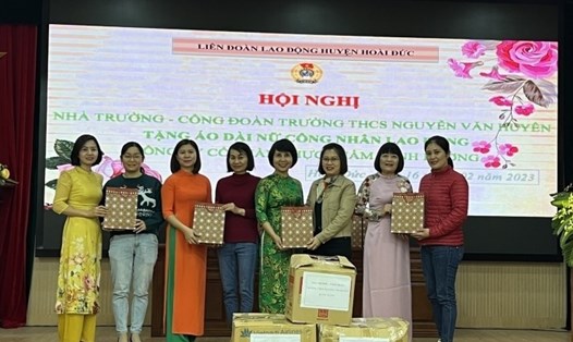 Ban chấp hành Công đoàn trường THCS Nguyễn Văn Huyên trao tặng áo dài cho Công ty Cổ phần thực phẩm Minh Dương. Ảnh: Anh Tuấn