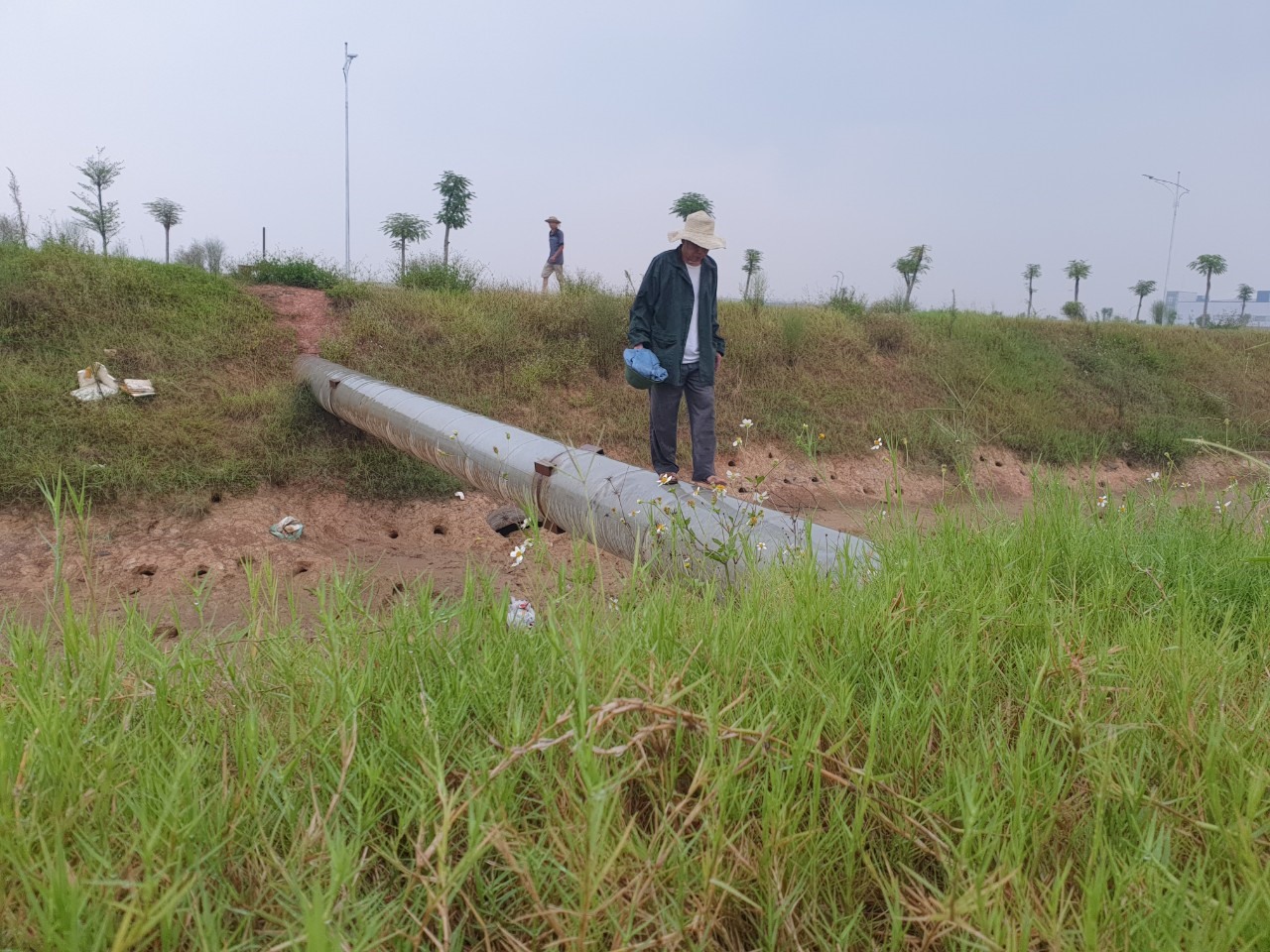 Nhiều người dân thôn Trác Bút muốn sang KCN Yên Phong 2C hiện phải đi trên đường ống nước như thế này. Ảnh: Trần Tuấn