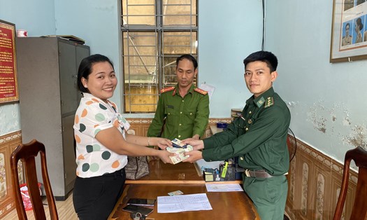 Trung uý Giang trao trả tài sản nhặt được lại cho chị Na tại cơ quan công an. Ảnh Biên Phòng.