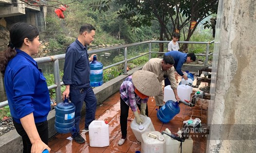 Người dân Quảng Ninh mang can, xách bình để đựng nước, tận dụng nguồn nước sạch về sử dụng. Ảnh: Lương Hà