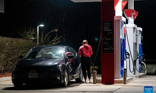 Một người phụ nữ đổ xăng cho ô tô tại một trạm xăng ở Arlington, Virginia, Mỹ. Ảnh: Xinhua