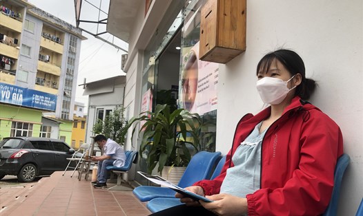 Chị Lê Ngọc Hà ngồi chờ kết quả xét nghiệm sau khi khám thai định kỳ tại Bệnh viện Nam Thăng Long cơ sở 2 sáng 22.2. 
Ảnh: Bảo Hân