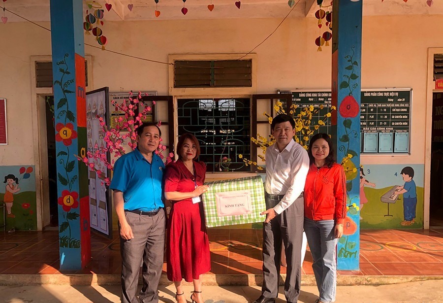 Chủ tịch LĐLĐ tỉnh Nghệ An Kha Văn Tám trao quà cho tập thể giáo viên Trường mầm non Keng Đu, huyện Kỳ Sơn. Ảnh: Thanh Tùng
