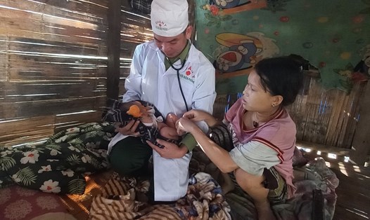 Thiếu tá Vũ thăm khám cho trẻ sơ sinh ở bản Pa Ling. Ảnh: T.Sơn.