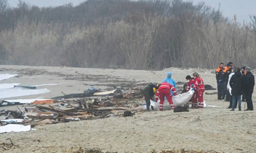 Lực lượng cứu hộ xử lý túi đựng thi thể tại địa điểm xảy ra vụ đắm thuyền chở người di cư ở Italia ngày 26.2.2023. Ảnh: ANSA