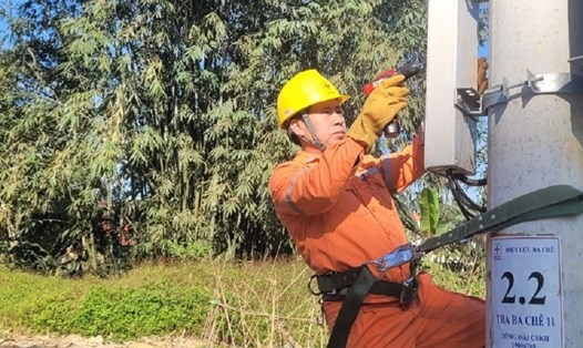 Anh Phạm Văn Hùng lắp đặt công tơ cấp điện mới cho khách hàng tại thị trấn Ba Chẽ. Ảnh: Lan Ngọc