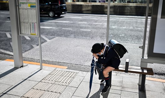 Một học sinh Nhật Bản đợi xe buýt tại khu vực Ginza của Tokyo. Ảnh: AFP