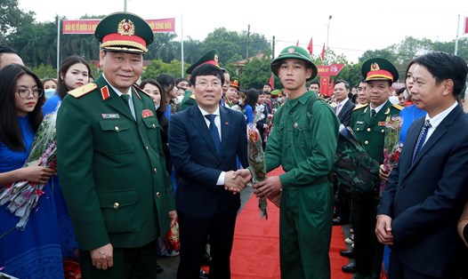 Thiếu tướng Trần Anh Du, Phó Tư lệnh Quân khu 2 và Chủ tịch UBND tỉnh Vĩnh Phúc Lê Duy Thành tặng hoa động viên tân binh lên đường nhập ngũ ngày 8.2. Ảnh: Thế Hùng