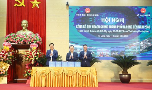 Thứ trưởng Bộ Xây dựng Nguyễn Tường Văn (trái) bàn giao tài liệu, công bố quy hoạch chung TP Hạ Long đến năm 2040. Ảnh: Đỗ Phương