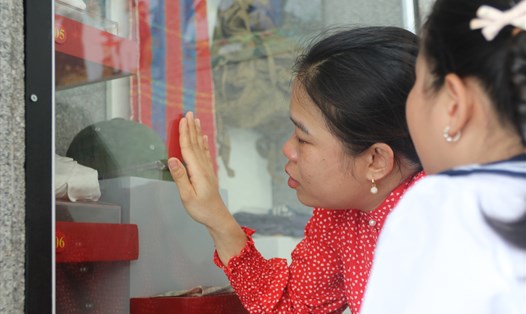 Con gái liệt sĩ Phan Huy Sơn (Nghệ An) xúc động trước kỷ vật của bố được lưu giữ tại bảo tàng Gạc Ma. Ảnh: Phương Linh