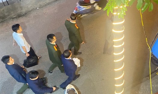 Ông Nguyễn Đình Đương (mặc áo xanh, tay cầm vải trắng) bị cơ quan công an áp tải, bắt giữ tối ngày 13.3. Ảnh: Đại An