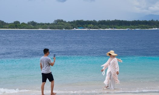 Khách du lịch chụp ảnh ở bãi biển Gili Trawangan trên đảo Gili ở Lombok, Indonesia ngày 18.3.2022. Ảnh: Xinhua