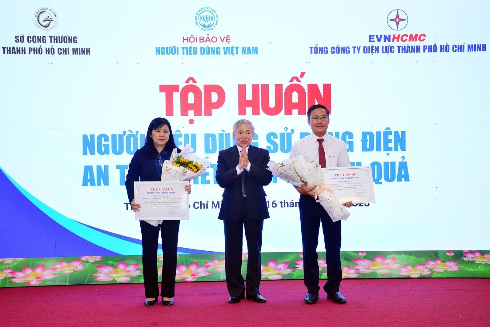 Ông Nguyễn Mạnh Hùng - Chủ tịch Hội Bảo vệ người tiêu dùng Việt Nam - tặng hoa đại diện Sở Công Thương và Tổng Công ty Điện lực TPHCM. Ảnh: EVNHCMC cung cấp