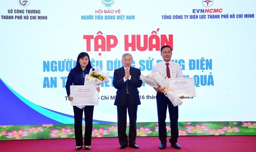 Ông Nguyễn Mạnh Hùng - Chủ tịch Hội Bảo vệ người tiêu dùng Việt Nam - tặng hoa đại diện Sở Công Thương và Tổng Công ty Điện lực TPHCM. Ảnh: EVNHCMC cung cấp