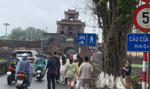 Khách du lịch chen chân với các phương tiện cơ giới tại cầu cửa Ngăn của Kinh thành Huế. Ảnh: Tường Minh