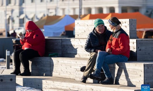 Tắm nắng tại một khu chợ ở Helsinki, Phần Lan, ngày 16.3.2022. Ảnh: Xinhua