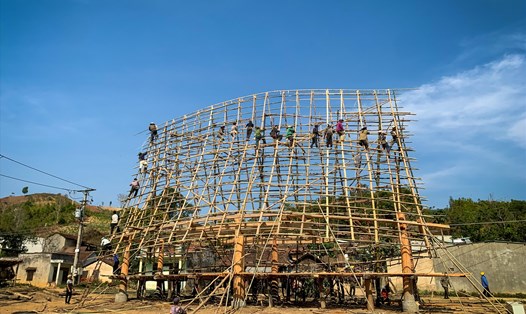Hàng chục thanh niên lợp mái nhà rông xã Đăk Tơ Lung theo mẫu nguyên bản. Ảnh Thanh Tuấn