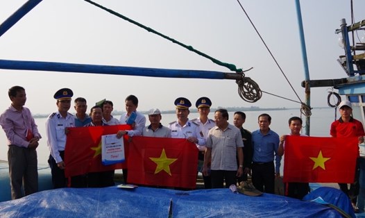 Bộ Tư lệnh Vùng Cảnh sát biển 2 tặng cờ Tổ quốc và quà cho ngư dân. Ảnh: Nguyễn Thành.