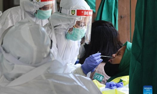 Nhân viên y tế lấy mẫu xét nghiệm COVID-19 ở Surakarta, Indonesia, ngày 22.10.2021. Ảnh: Xinhua