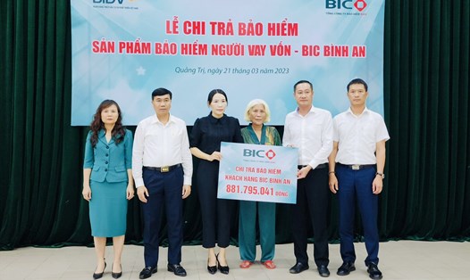 Đại diện lãnh đạo BIC và BIDV Quảng Trị trao tiền bảo hiểm cho gia đình khách hàng. Ảnh: BIC
