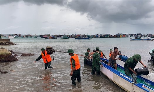 Lực lượng vũ trang hỗ trợ người dân trục vớt các phương tiện bị chìm do mưa dông gây ra. Ảnh: Nguyên Anh/Kiên Giang