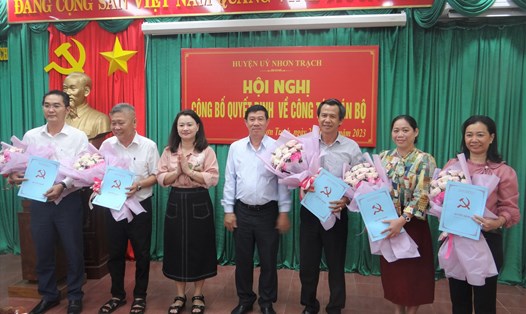 Lãnh đạo huyện ủy – UBND huyện Nhơn Trạch trao quyết định và tặng hoa chúc mừng các đồng chí nhận nhiệm vụ mới. Ảnh: Xuân Mai