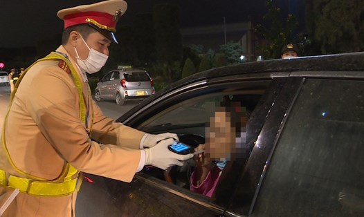 Lực lượng CSGT kiểm tra nồng độ cồn với một nữ tài xế. Ảnh: Cục CSGT
