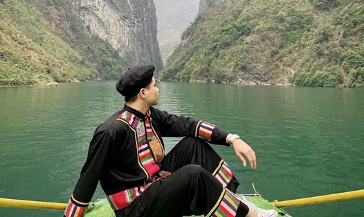 Khách du lịch chụp ảnh với trang phục truyền thống của một số đồng bào dân tộc tỉnh Hà Giang tại khu du lịch sông Nho Quế.